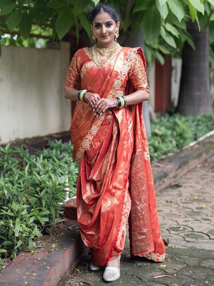 A confident standing pose in the red Nauvari saree, showing how the traditional drape creates a powerful and elegant silhouette.