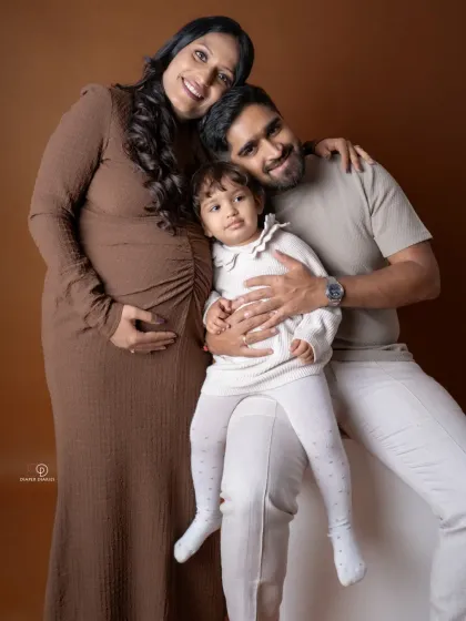 The same family portrait in color. The warm brown and neutral tones create a soft and cohesive look for this growing family.