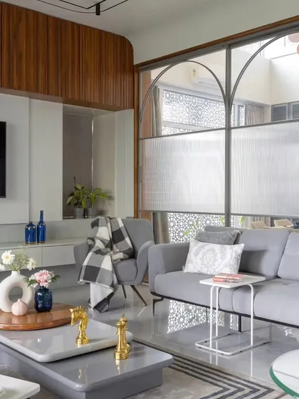 We designed this living room to be both stylish and comfortable. The space features a custom floating TV unit, a plush sectional sofa, and a unique glass partition that separates the area without closing it off, maintaining an open and airy feel.