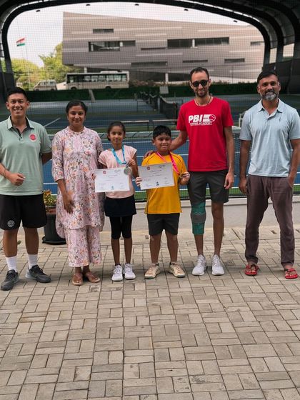 Coaches and parents celebrating with young medal winners. The collaborative spirit between our team and families is fundamental to our players' success and enjoyment.