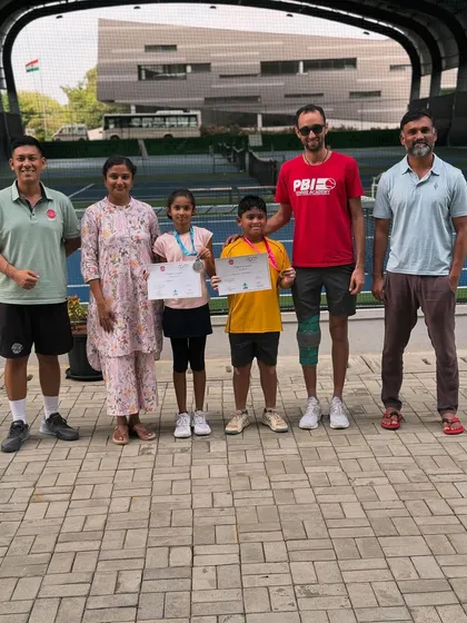 Coaches and parents celebrating with young medal winners. The collaborative spirit between our team and families is fundamental to our players' success and enjoyment.