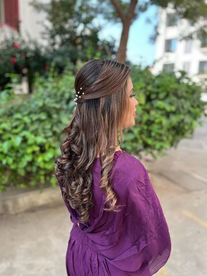 Soft, bouncy curls with a simple twist and pearl accessories. This hairstyle is perfect for a modern and chic look.