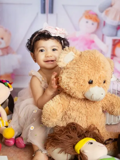 A playful moment with her favorite teddy bear. These interactions create genuine and heartwarming photos.