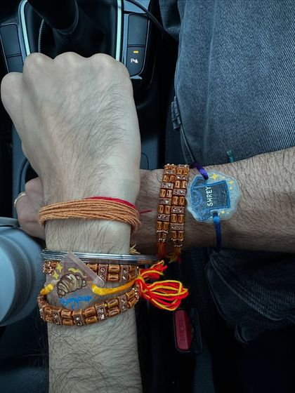 A brother's wrist full of Rakhis, including our unique, personalized ones.