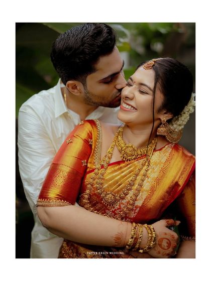 A tender moment from a Hindu wedding, the groom's gentle kiss on the bride's cheek is full of love and affection.