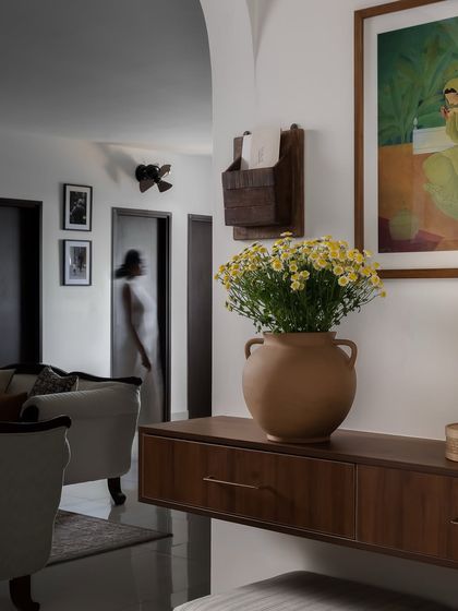 A wider view of the foyer, showing the floating console and its connection to the living area. The archway provides a glimpse into the home, inviting you further in.