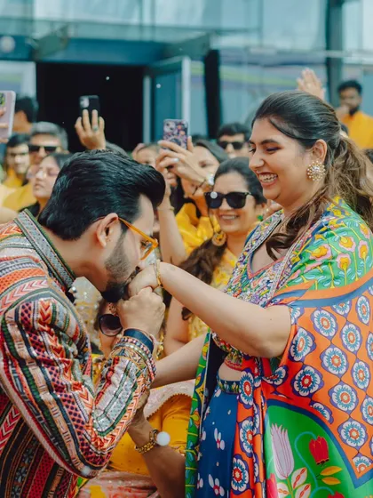 A sweet moment during the Mehendi carnival, where the groom kisses the bride's hand. Even amidst the chaos, we find and capture these romantic gestures.