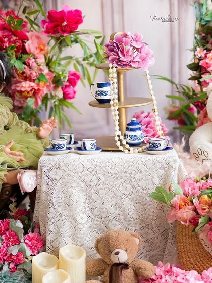 A whimsical tea party for one to celebrate a first birthday. This elaborate setup with flowers and teddy bears creates a magical fairytale setting for your baby girl.