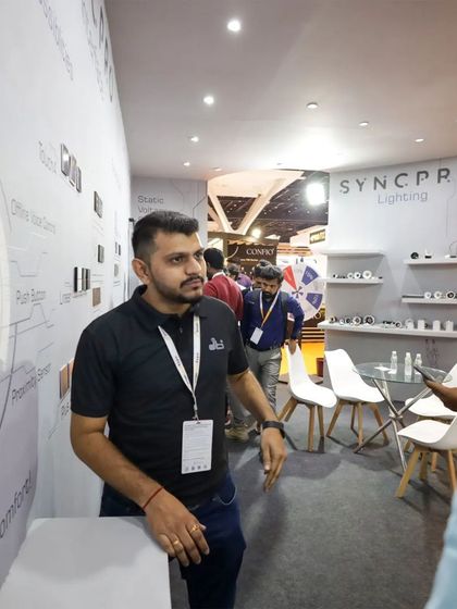 A member of our team standing by the SyncPro product wall, ready to demonstrate our range of smart keypads and lighting solutions to expo attendees.