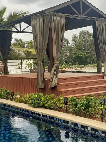 We designed this stunning poolside gazebo at Prestige Golfshire, Bangalore, for Mr. Anurag. It features a raised WPC deck and is surrounded by lush plants, creating a tranquil escape right by the water.