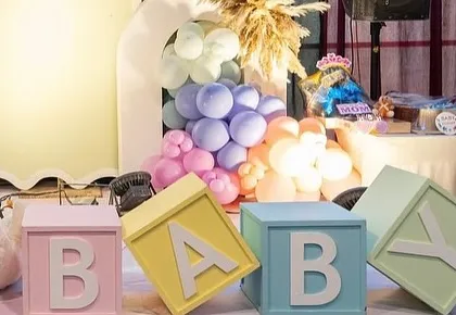 We use props like these oversized, pastel-colored 'BABY' blocks to add a playful and photogenic element to our decor setups.