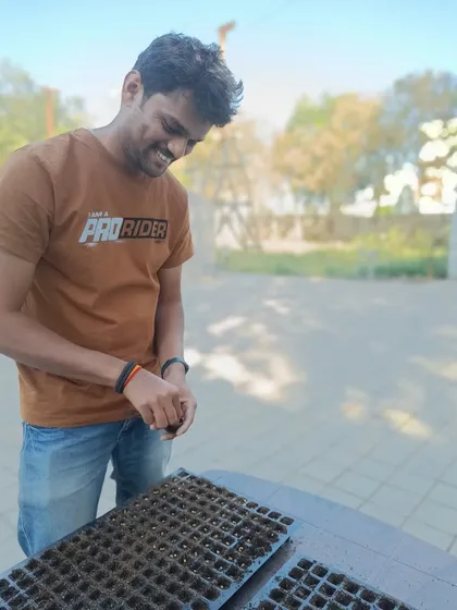 Our design and development engineer, Sumanth, takes a break to help the team sow seeds. Everyone on our team is involved in the process of growing food.