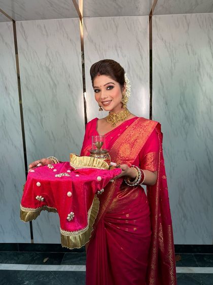 The complete Karwa Chauth look, with the bride holding her puja thali, looking absolutely divine in her pink saree and our temple jewellery.