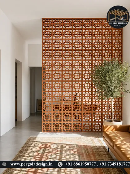 A large terracotta jali screen serves as an elegant room divider in a minimalist interior. The natural material and geometric pattern add texture and warmth, complementing the modern decor.