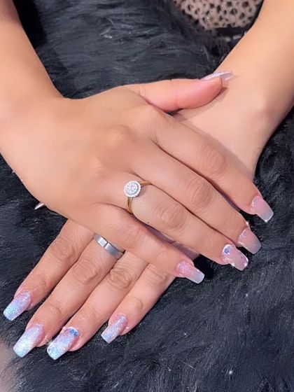 A delicate glitter ombré on square extensions, with subtle 3D bow accents for a touch of sweetness.