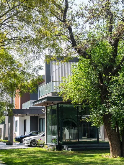 A view of Triveni Farmhouse through a canopy of mature trees. I always aim to preserve the existing landscape, allowing the architecture to nestle into its surroundings rather than dominate them.