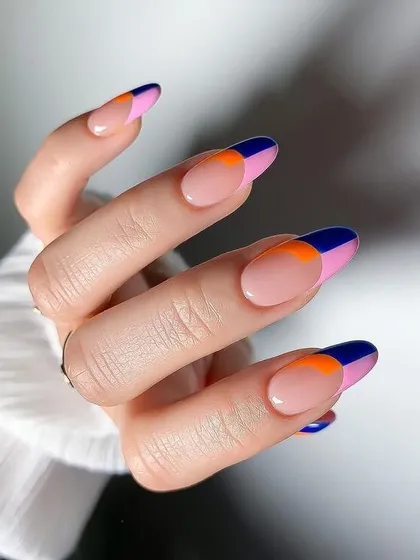 A bold and graphic French manicure with color-blocked tips in navy blue and orange. This modern design is perfect for those who love a pop of unexpected color.