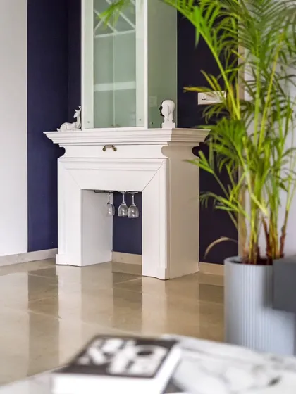This custom bar unit, inspired by a classic English fireplace, is a subtle yet prominent feature in the living room. The intricate moulding and deep blue background make it a true conversation piece.