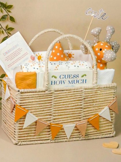 A gender-neutral baby hamper with a giraffe toy and 'Guess How Much I Love You' book. The orange and white theme is bright and modern.