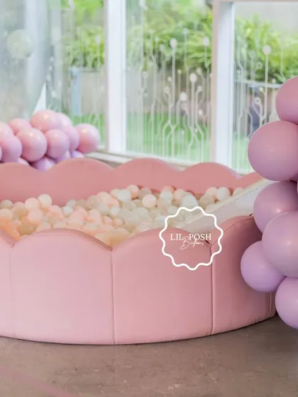 Another view of the beautiful ball pit, surrounded by pastel pink balloon clusters.