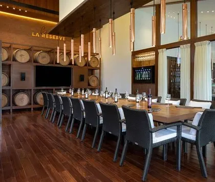 Another view of the 'Cave de la Reserve', showcasing the elegant long table and custom lighting. This room is designed to provide an immersive and sophisticated environment for enjoying our finest wines.