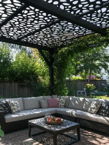 A garden pergola with a beautiful, organic-patterned CNC-cut roof provides dappled shade for a comfortable outdoor sectional sofa. This design integrates seamlessly with the natural surroundings, creating a peaceful backyard oasis.