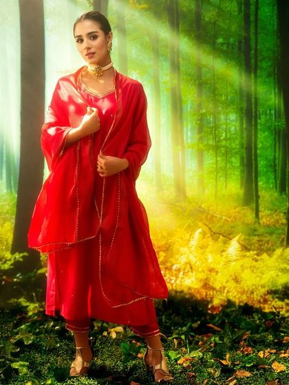 A magical, sun-drenched forest, created with projection. The beams of light filtering through the trees add a divine, ethereal quality to this vibrant ethnic wear shot.