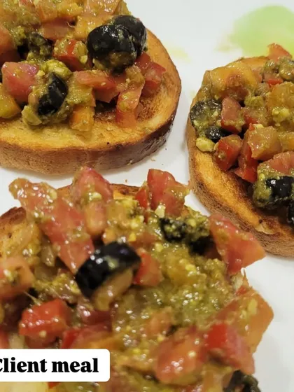A client's meal of bruschetta with fresh tomatoes, olives, and pesto. A delicious and healthy appetizer or snack.