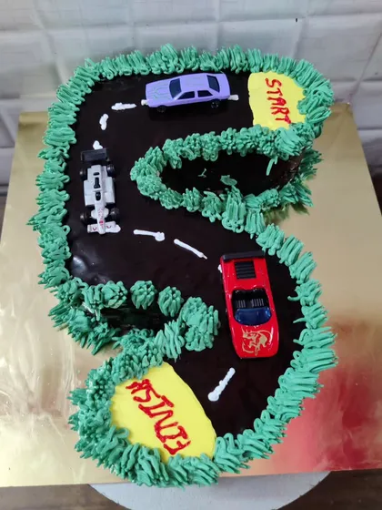 A number '5' shaped cake designed as a racetrack. This creative design is perfect for a car-themed birthday party.