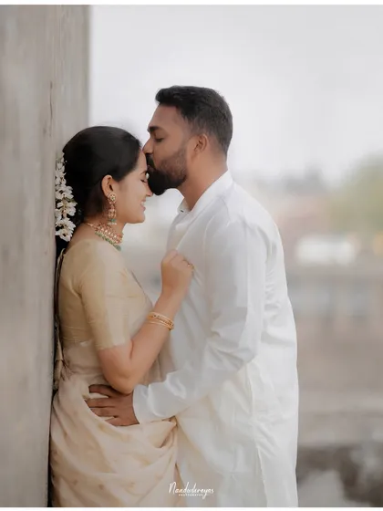 A gentle forehead kiss against a simple wall, proving that powerful moments can be found in the simplest of settings.