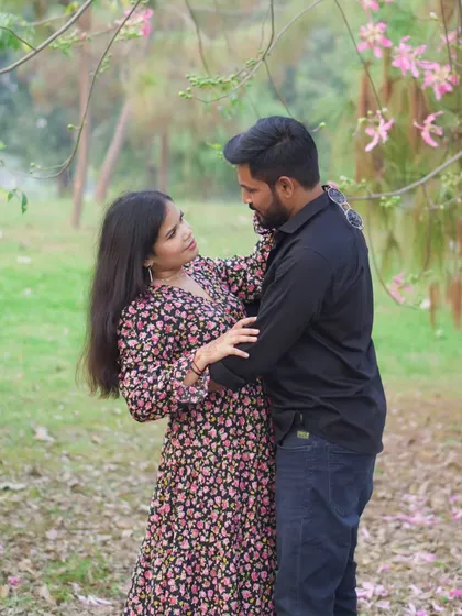 An intimate, romantic shot of the couple looking at each other, taken during their pre-wedding session among blooming trees.