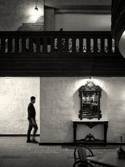 A person walks past a decorative mirror, highlighting the scale and flow of the ground floor space.