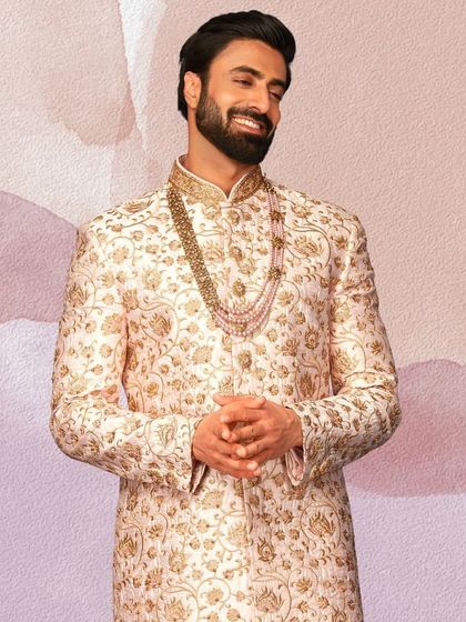 We believe we have the perfect groom's wear for you. This elegant floral embroidered sherwani paired with a pearl necklace is a testament to our collection's quality.