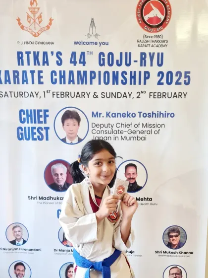 A young silver medalist poses in front of the banner for our 44th Goju-Ryu Karate Championship. The event was a grand success, with participation from students of all ages.
