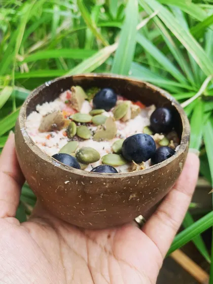 A simple, nutritious meal served in a coconut shell. This mix includes steamed meat, veggies, and is topped with pumpkin seeds and blueberries for extra goodness.