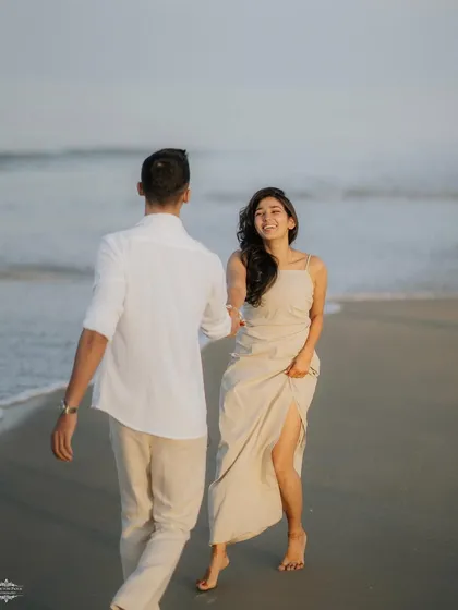 A beautiful candid moment as a couple walks along the water's edge. This "follow me" style shot feels natural and captures a genuine smile.