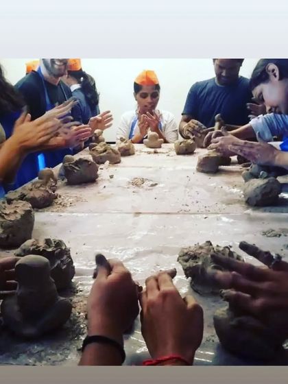 A moment from our eco-friendly Ganesha workshop, where participants are gathered around the table, learning to shape the clay with prayers and focus.