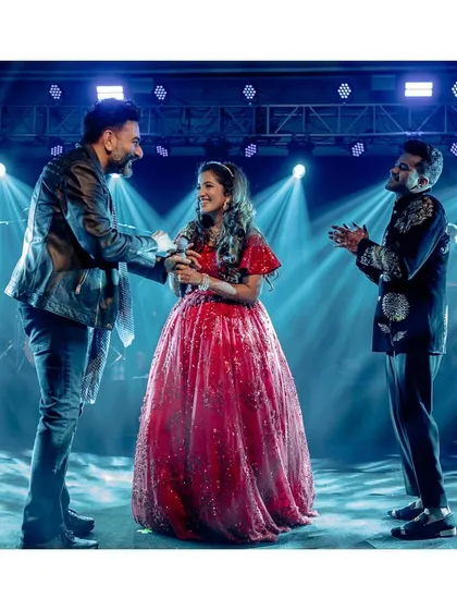Deeksha gets a high-five from Shekhar after her impromptu performance. Her joy and his appreciation make this one of the most memorable moments of the wedding.