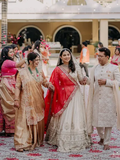 A heartwarming moment as Khushali walks to her wedding ceremony, holding hands with her parents, surrounded by the love and blessings of her family.