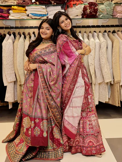 Posing back-to-back, these friends showcase two different pink lehengas, proving that coordinated doesn't have to mean identical.