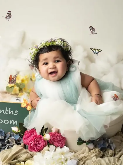 "Six Months in Bloom." This photo celebrates the half-year milestone with a beautiful floral and butterfly theme, capturing her joyful and curious spirit.