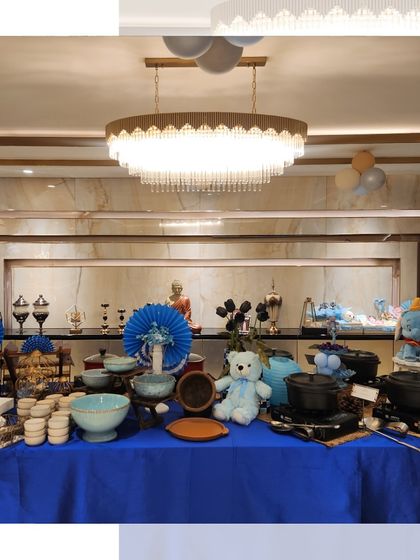 A wide shot of the blue-themed baby boy celebration. The elegant setup includes a full buffet line under a beautiful chandelier, creating a grand and welcoming atmosphere.