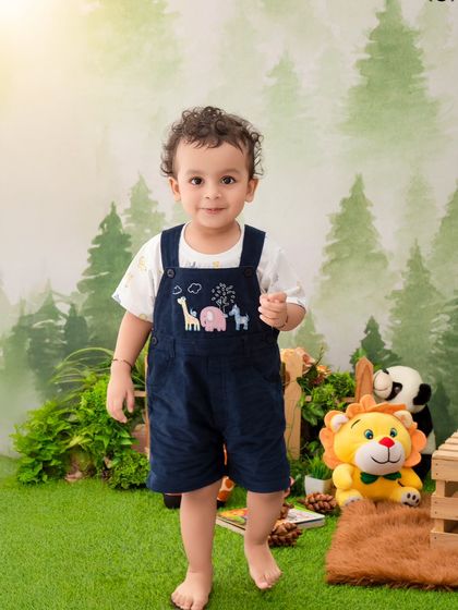 This little explorer is standing tall in his jungle-themed outfit, ready for an adventure with his plush animal friends.