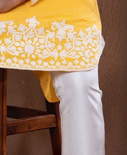 A detail shot of the embroidered hem of the zesty yellow kurta.