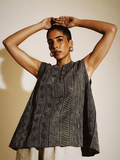 A strong and simple studio portrait for House of Wandering Silk. The focus is on the model's confident gaze and the elegant lines of the top.