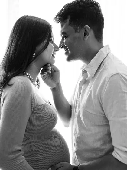 A classic black and white close-up. The focus is entirely on their expressions and the gentle touch, creating a timeless and emotional portrait of the couple.