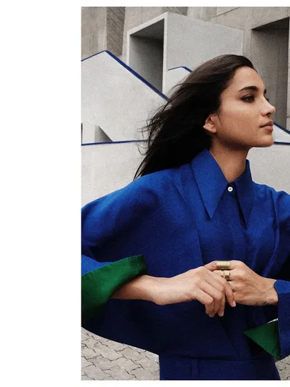 A detail shot showing the unique winged sleeves of this blue Payal Khandwala shirt, set against the geometric lines of the building.