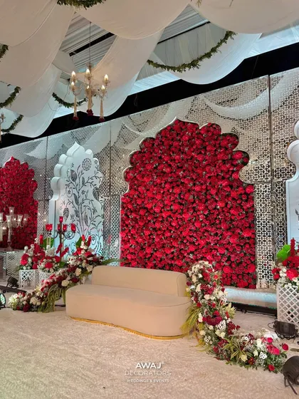 A side angle of the regal red and white stage, showing the depth of the floral arrangements and the intricate 'jaali' work on the side panels.