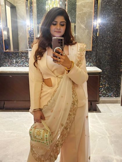 A closer view of the fusion powersuit, showing how the emerald necklace and gemstone clutch add a touch of personal resonance to the overall look.