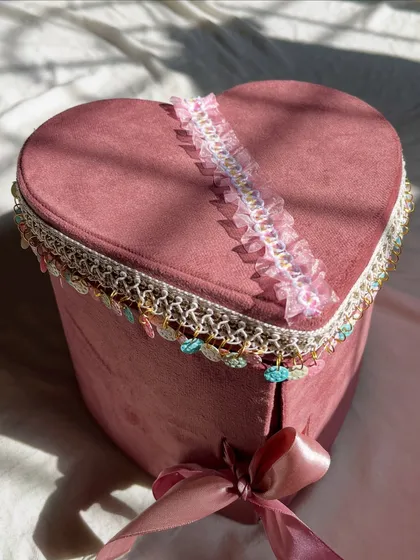 The elegant exterior of the pink suede heart shaped box, decorated with lace and a satin ribbon. It’s a keepsake box they can cherish forever.